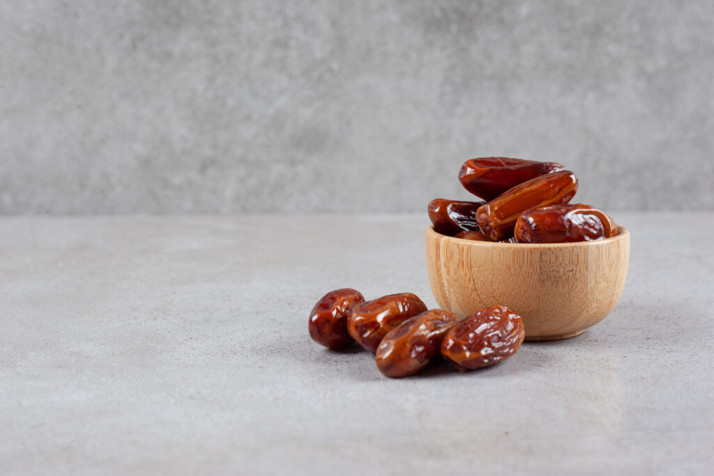 small bowl dates handful marble background high quality photo